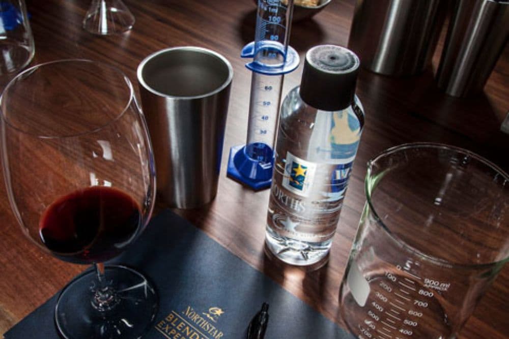 Wine glass, bottle of alcohol and various test tubes and glass containers on a table